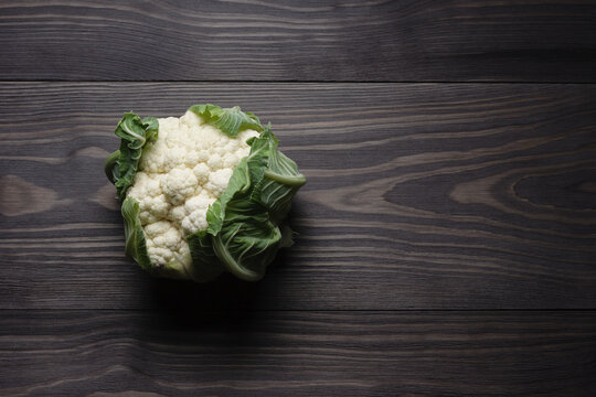 Raw head of cauliflower on wooden table copy space