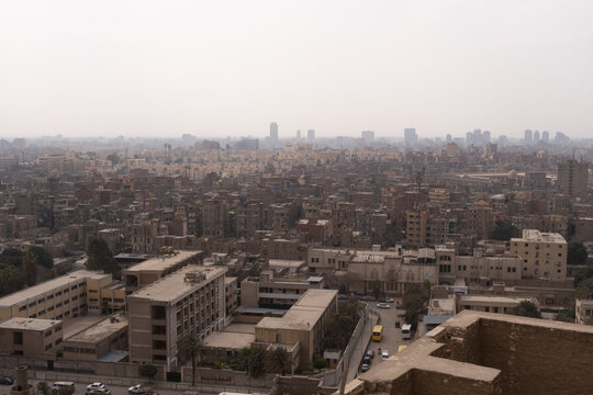 Aerial view of the dense urban landscape of Cairo with hazy sky and crowded buildings in Cairo, Cairo Governorate, Egypt.