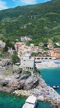 Aerial view of tower on rocky hill in Monterosso al Mare, Cinque Terre, with turquoise sea and coastline