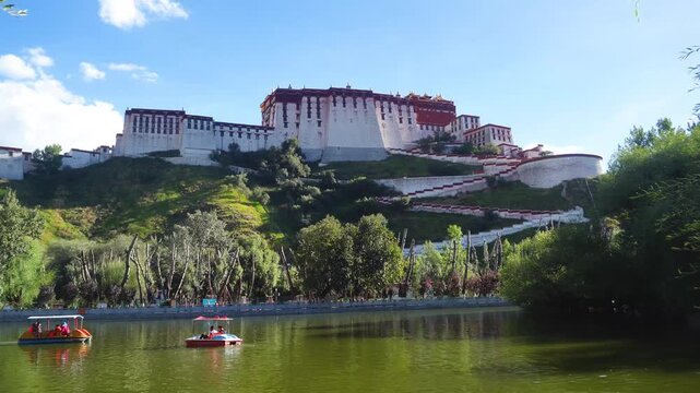 Potala Palace in Lhasa Tibet with游客 pedal boats on lake under clear blue sky