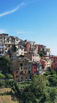 Establishing aerial shot of colorful hillside house village Corniglia in Cinque Terre, Italy, vertical video
