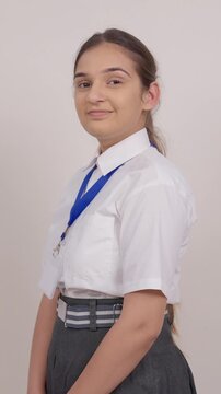 Vertical Shot of Indian Schoolgirl Turing Around and Smiling at Camera