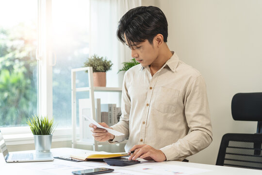 Deduction planning, debt asian accountant hand using calculator to calculating money balance from bill and income, cost budget expenses for pay money form personal individual on table at home.