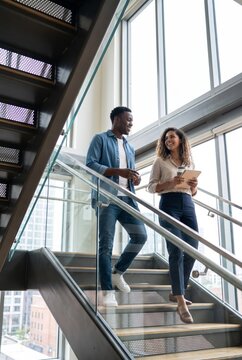 Business coworkers walking down office stairs