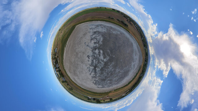 Aerial view of Little Gaynor Lake in a 360-degree tiny planet perspective, showing the dry lake bed surrounded by agricultural fields and rural roads in Longmont, Colorado, United States.