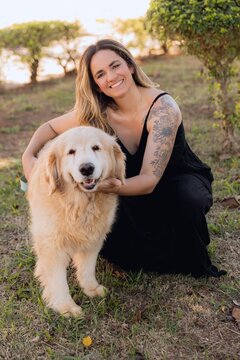 Mulher sorrindo com cachorro golden