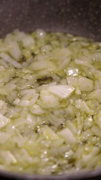 Sauteing diced onion in hot olive oil. Cooking at home.
