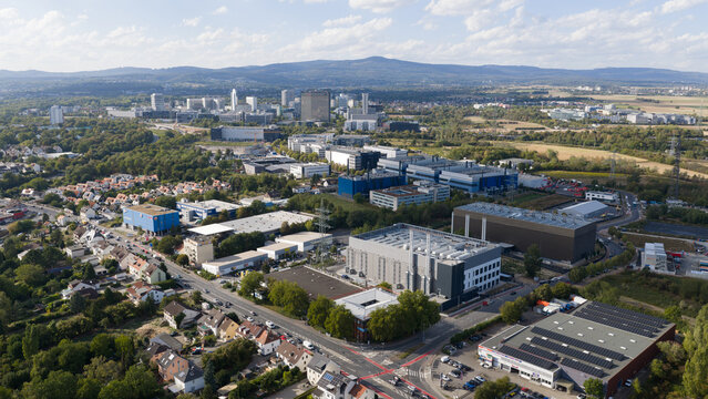 Aerial view of modern industrial and commercial buildings with warehouses, office complexes, and surrounding greenery in Frankfurt am Main, Hessen, Germany.