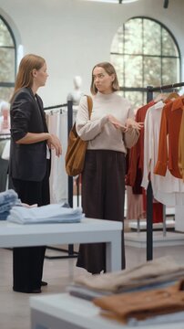 Vertical Screen. Beautiful Smiling Female Customer Shopping in Clothing Store, Choosing Stylish Clothes, Picking Dress, Blouse. People in Fashionable Shop, Colorful Brand, Sustainable Designs