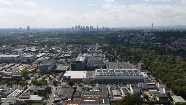 Aerial view of the industrial district and surrounding urban landscape with the Frankfurt skyline visible in the distance, Frankfurt am Main, Hessen, Germany.