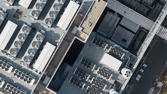 Aerial view of industrial rooftop featuring numerous HVAC cooling units and ventilation systems in Frankfurt am Main, Hessen, Germany.