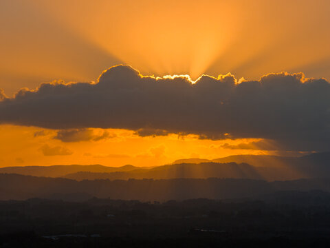 Aerial view of the golden sunset over the rolling hills and clouds in Byron Bay, New South Wales, Australia.