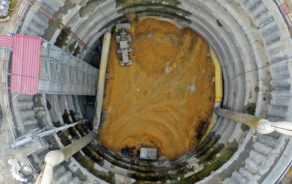 Aerial view of a large circular construction excavation site with heavy machinery, scaffolding, and pipes in Bursa, Bursa, Turkiye.