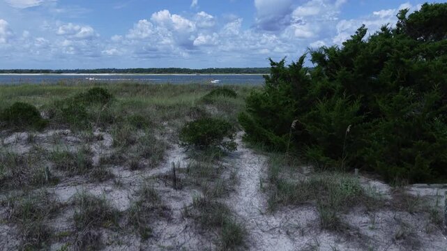 Wrightsville Beach, NC sand dunes on coastal with inlet waterway and boat