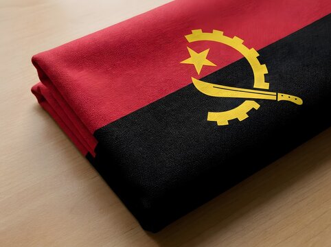 Folded flag of angola on a wooden surface