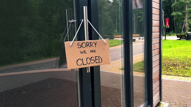WE ARE CLOSED notice on cafe entrance. Small business closes due to Financial struggles. High prices cause customer falling