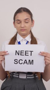 Vertical Shot of Schoolgirl Standing with NEET SCAM Poster