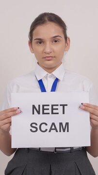 Vertical Shot of School Girl Standing with NEET SCAM Poster