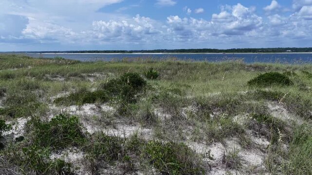 Aerial rising over sand dunes at Wrightsville Beach, NC to scenic inlet coastal waterway