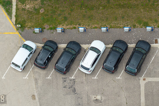 Aerial view of electric car charging station with several vehicles parked in a row on asphalt in Poland.