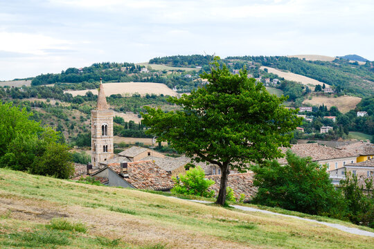 Bell tower of San Francesco rising above rooftops and hills in Urbino, Marche, Italy