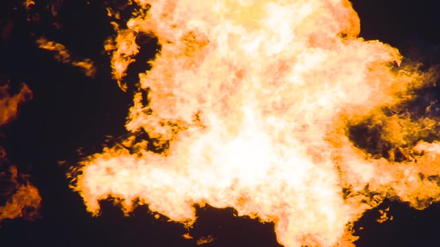 Blazing Hot Gas Cloud. A powerful pillar of bright flame with swirling fiery tongues in the air on a black background