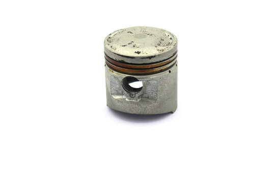 A piston from a 4 stroke motorcycle engine on a white background.