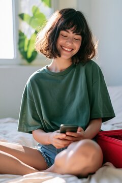 Young woman on bed smiling while using phone for lifestyle banner and social media background with natural light