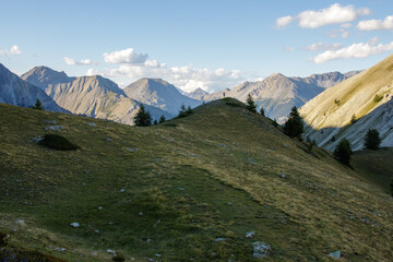 Paysage alpin avec randonneur sur colline les bras levés © Arnaud