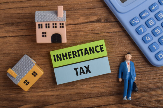 Inheritance tax concept featuring property, calculator, businessman, and wooden blocks, representing estate planning, taxation, wealth transfer, and financial management.