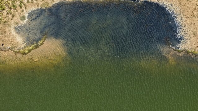Aerial view of the shoreline with green water and sandy banks in Erie, Colorado, United States.