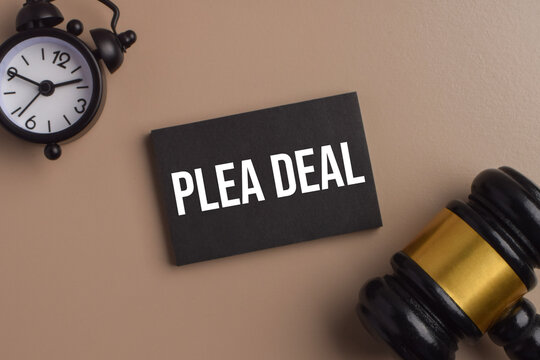 Plea deal concept featuring a black card, gavel, and alarm clock, representing legal negotiation, criminal justice, court proceedings, agreements, and settlement.
