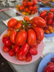 Fresh red tomatoes displayed on plates © wittawat khampakdee