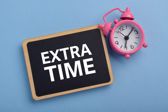 Alarm clock and blackboard labeled Extra Time, symbolizing deadlines, extensions, time management, productivity, scheduling, and urgency.