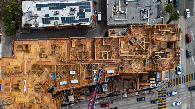 Aerial view of a wooden construction site with structural framing and a crane at South San Vicente Boulevard and South Fairfax Avenue in Los Angeles, California, United States.