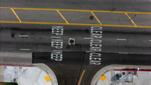 Aerial view of the intersection of South San Vicente Boulevard and South Fairfax Avenue with road markings reading Keep Clear in Los Angeles, California, United States.