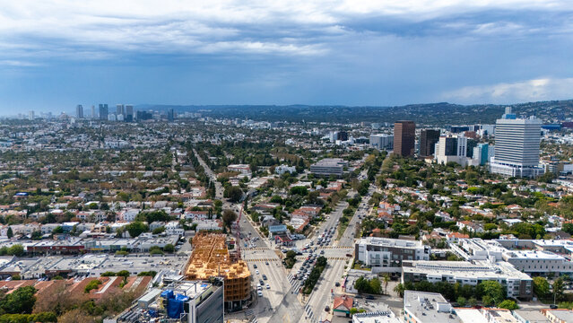 Aerial view of the intersection of South San Vicente Boulevard and South Fairfax Avenue with urban sprawl and distant skyscrapers in Los Angeles, California, United States.