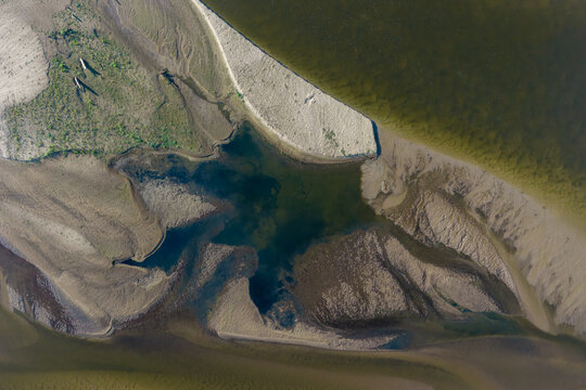 Aerial view of the Vistula River featuring intricate sandbanks, shallow water channels, and natural sediment patterns in Poland.