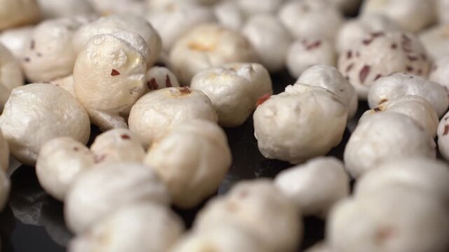 Close-up view of roasted fox nuts or gorgon nut, Euryale ferox, pop lotus seeds as healthy snack food and vegetarian diet element