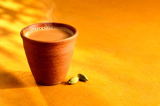 Traditional hot masala tea in a clay cup with cardamom seeds chai tea hot beverage