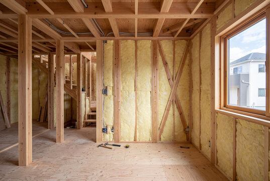 木造軸組と断熱材が見える新築一戸建て住宅の内装工事現場