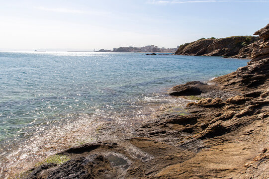 Sunlit Mediterranean coastline with cCliffs and turquoise waters in Algeria