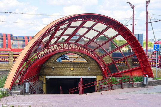 Staircase descent into underground pedestrian passage featuring a striking red spherical dome ceiling, modern city urban architecture.