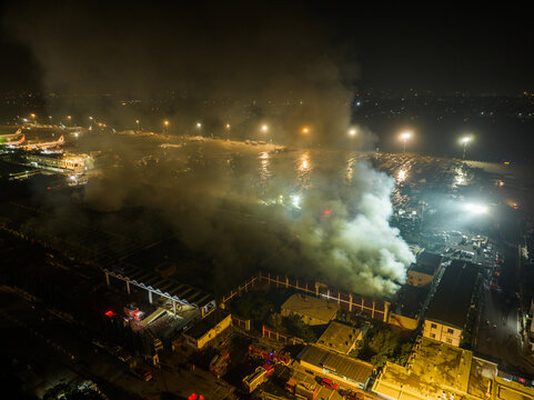 Aerial view of a fire burning at a building complex at night with emergency fire trucks on the scene in Dhaka, Dhaka Division, Bangladesh.