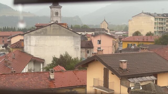 Italy, September 10, 2025. Borgo San Dalmazzo, Italy
Atmospheric view of a historic Italian town from an attic window during rainy weather.
   Author: Djundiet A.