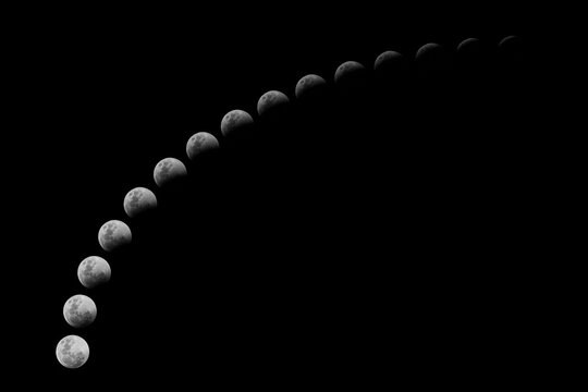 Different stages of a lunar eclipse in an arc against a dark sky. The photos were taken in South Africa during the lunar eclipse in June 2011.