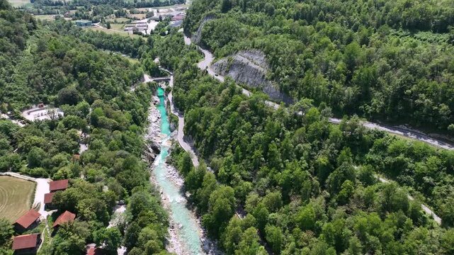 Aerial top down perspective captures turquoise Soca river crystal clear water. rocky canyon banks surrounded by dense wild green forest near Kobarid.