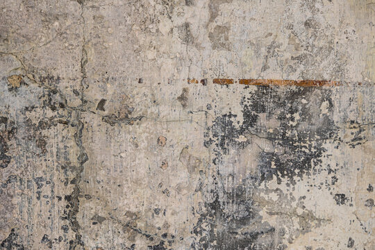 superficie che mostra la texture di un muro invecchiato o rovinato, simile a un intonaco consumato