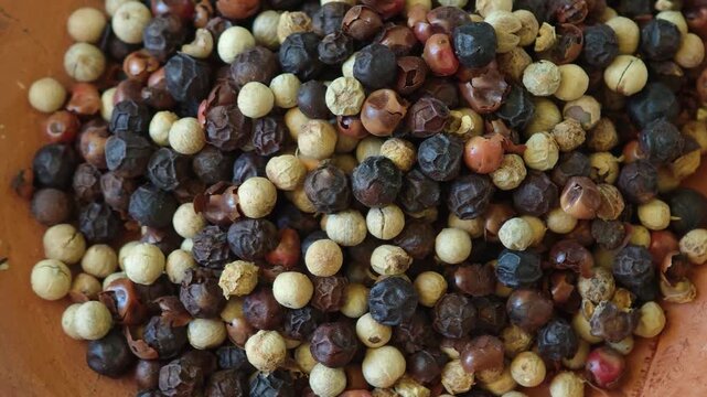 Close up of peppercorns in various colors showcasing their diverse textures