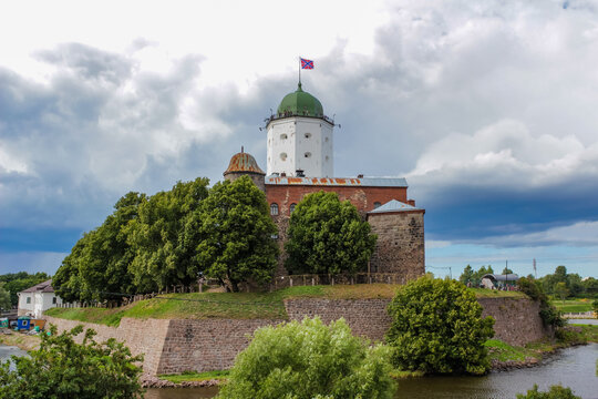 A rusty-domed stone tower nestled among trees, open-air, showcasing historic architecture and the surrounding natural environment